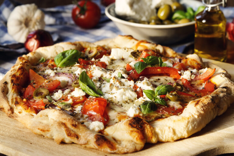 Hearty Greek Style Pizza with Feta Cheese, red onions, tomatoes, olives, garlic and herbs